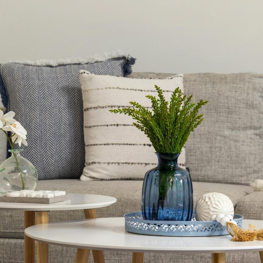 a couch with a table and a vase with flowers on it