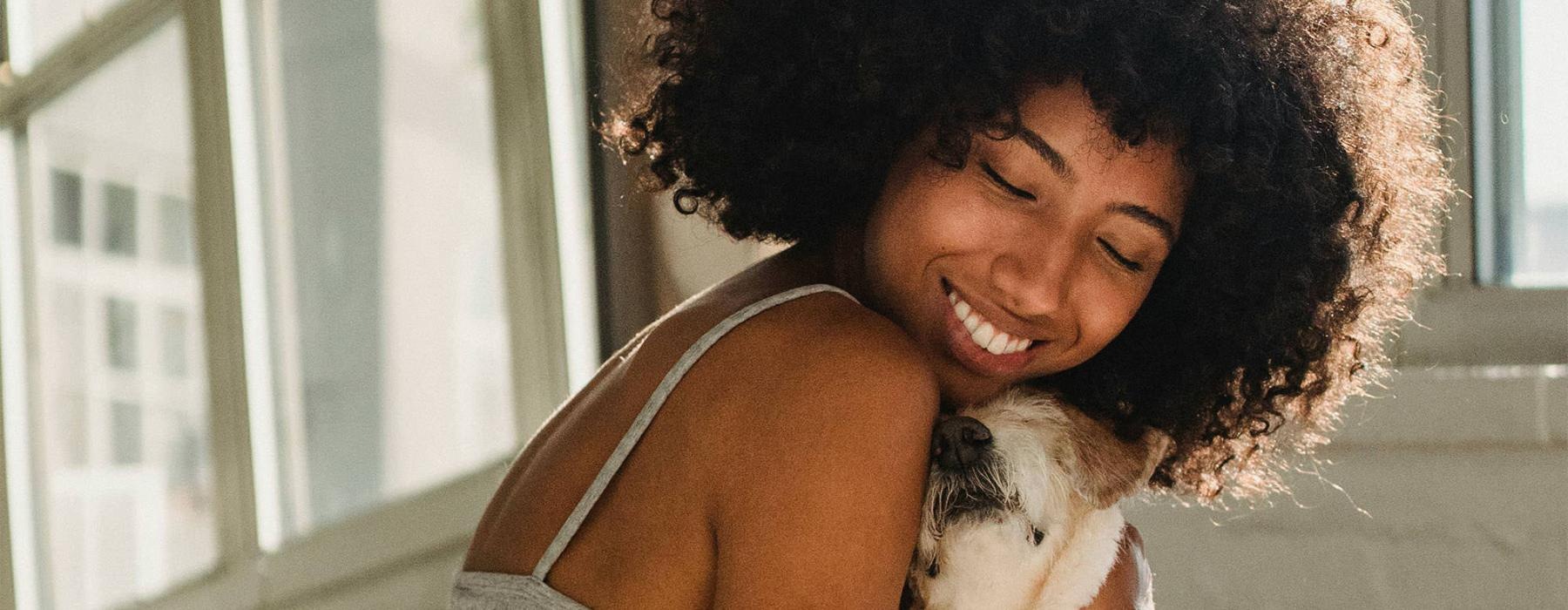 a girl on a bed hugging her dog