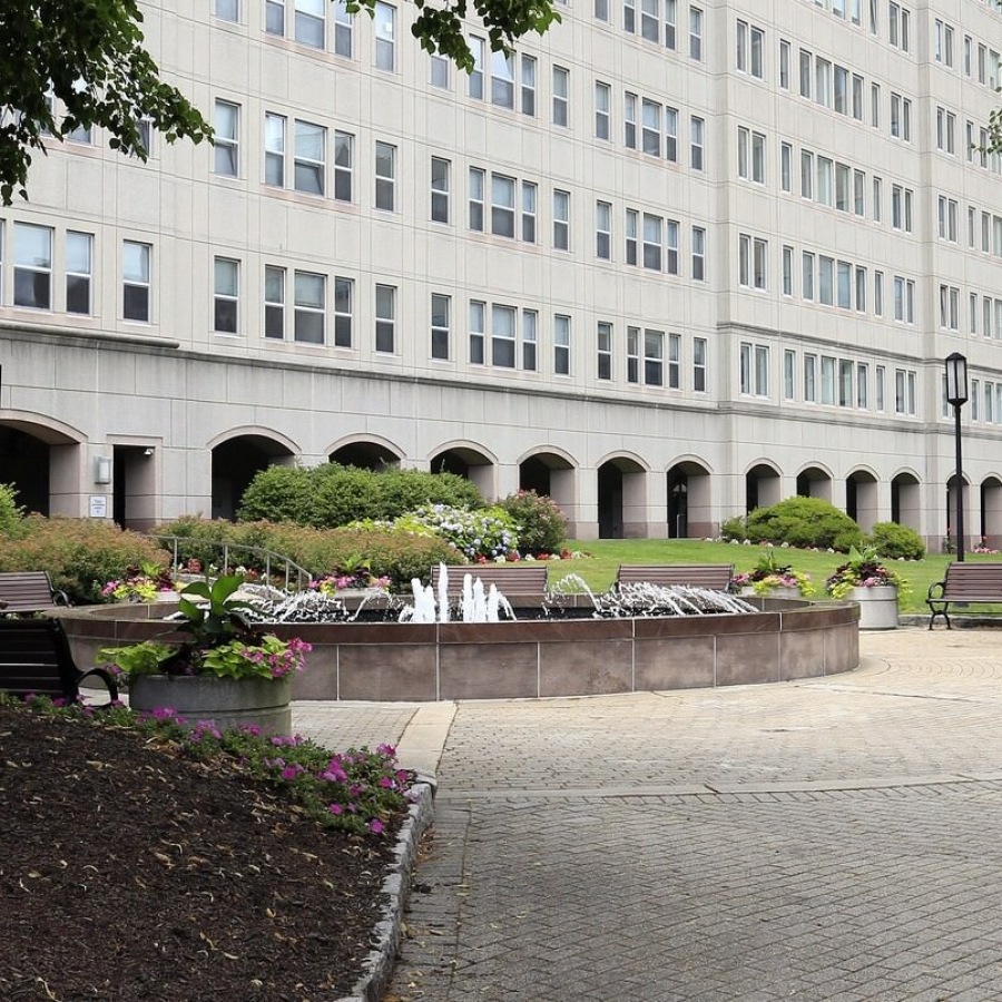a large building with a fountain and trees